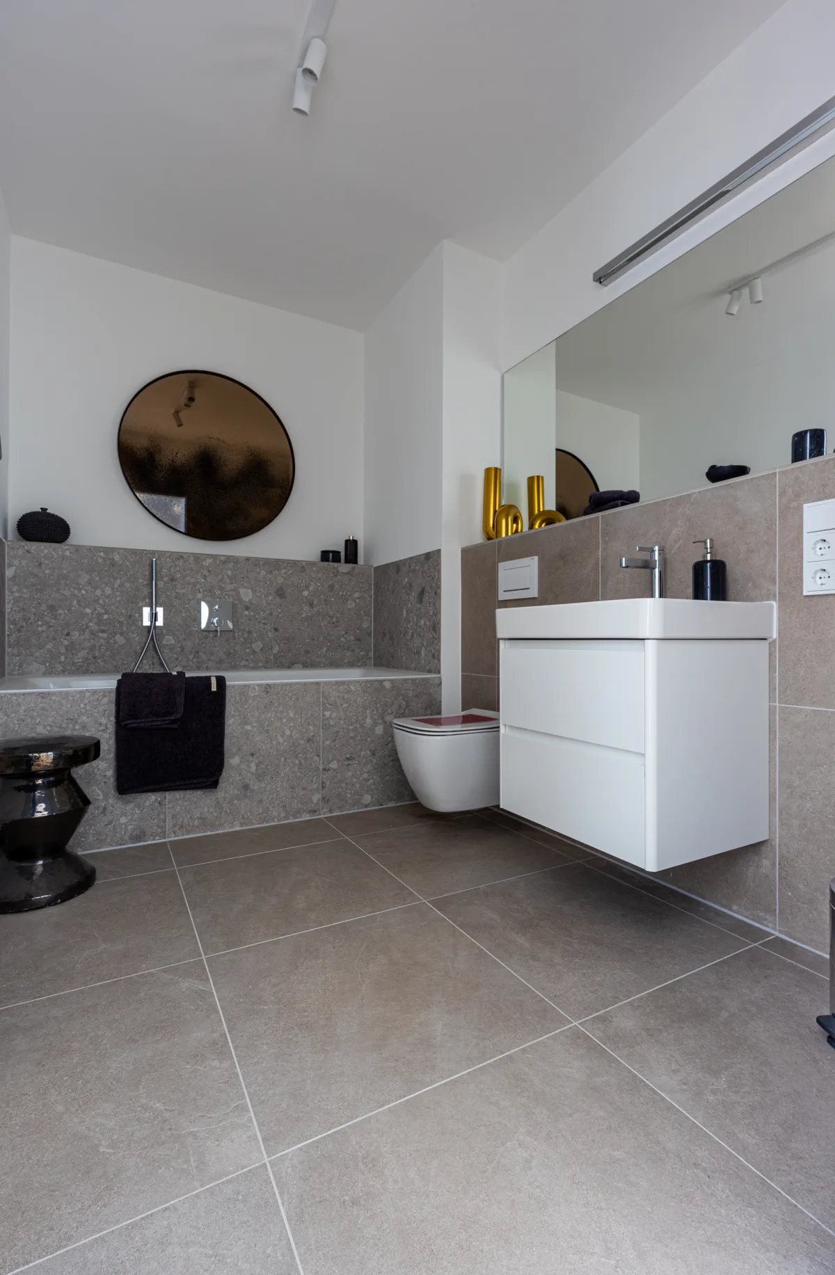 Helles Badezimmer mit graubeigen Boden- und Wandfliesen