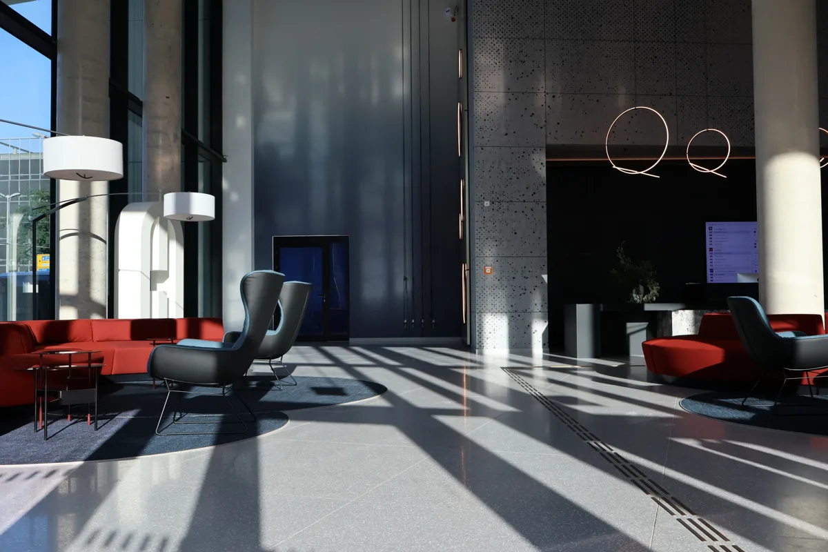Lichtdurchflutete Lobby mit großflächigem Steinboden im Projekt Pandion Düsseldorf